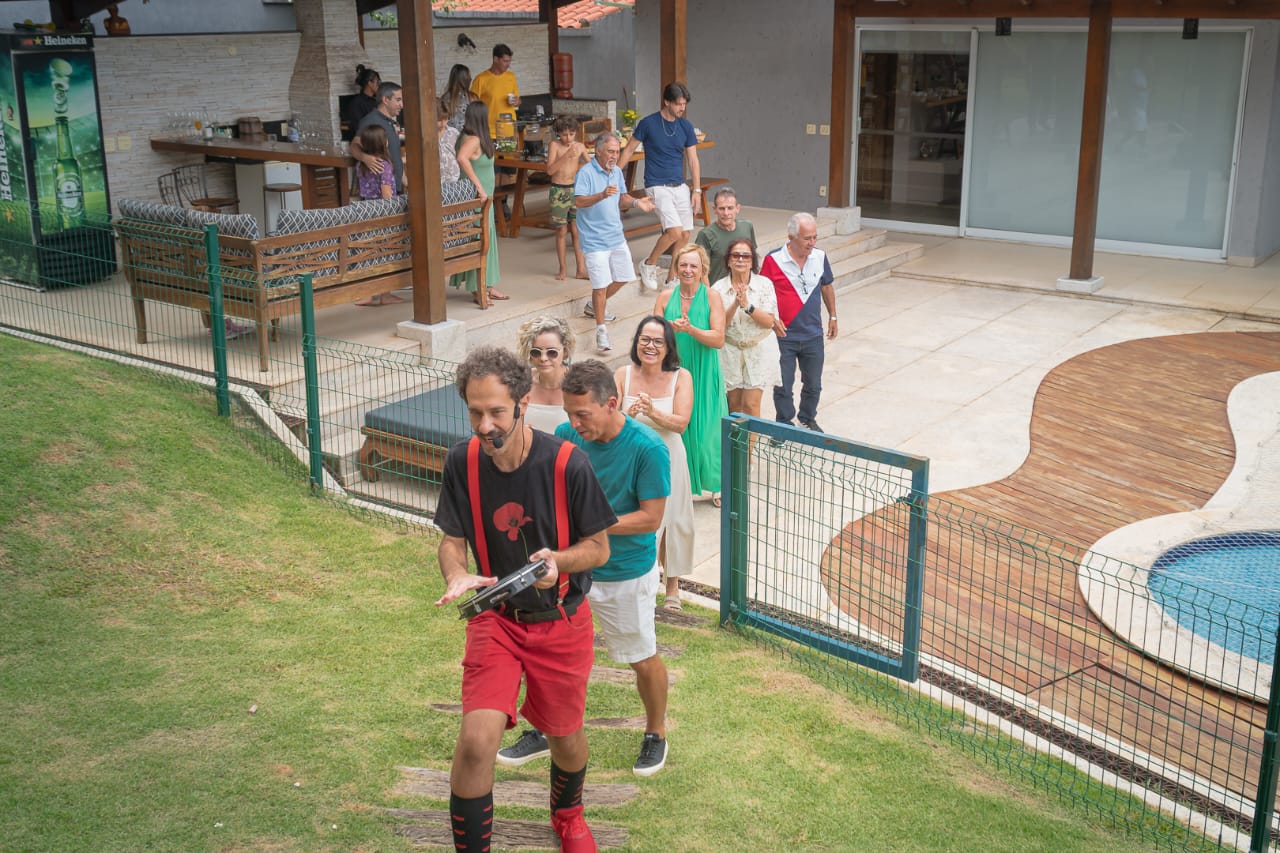 Edu Pio liderando cortejo musical em jardim